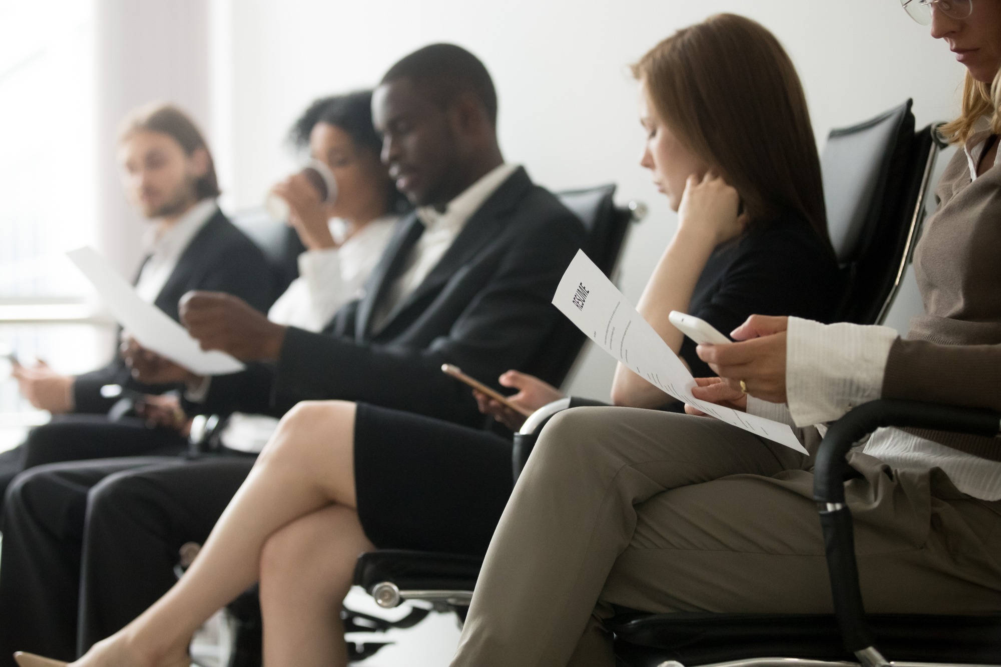 Multi-ethnic applicants sitting in queue preparing for interview